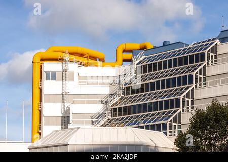 Étrange bâtiment avec de grandes conduites de chauffage jaunes pour garder les appartements résidentiels au chaud. Banque D'Images