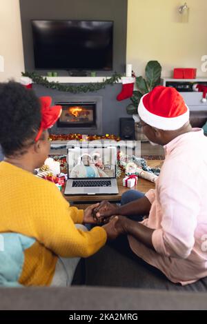 Couple afro-américain senior ayant un appel vidéo de noël avec un couple afro-américain senior Banque D'Images