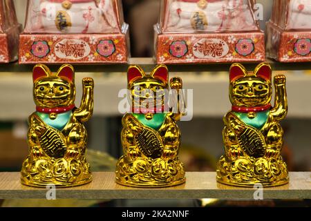 Gros plan de trois salutations Maneki Neko avec la patte Banque D'Images