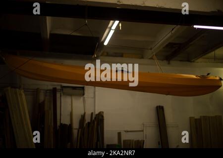 Le bateau est suspendu au plafond. Bateau dans le garage. Transport d'eau jaune. Équipement sportif en stock. Banque D'Images