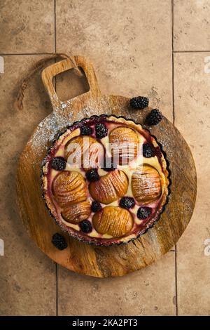 Tarte aux pommes. Gâteau aux pommes et aux mûres ou tarte au sucre en poudre sur une ancienne table en bois. Délicieux dessert pour le dîner d'automne ou d'hiver. Pâtisserie d'automne Banque D'Images