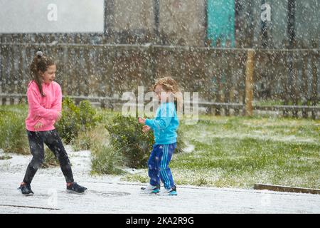 Dublin, Irlande - 04.10.2021: Les enfants jouent dans la cour avec la première neige. Banque D'Images