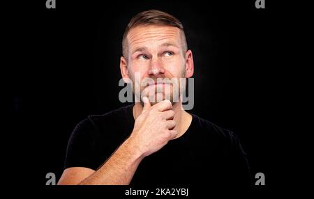 Un homme avec une barbe pense à quelque chose. Banque D'Images