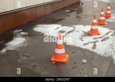 Cache de dissimulation sur l'asphalte. Zone d'urgence. Chute de neige du toit. Zone clôturée des piétons. Banque D'Images