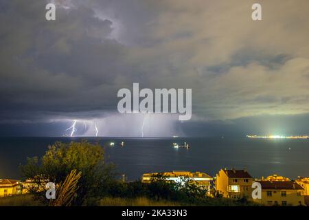 La foudre frappe la mer de Marmara au large de la côte de Tekirdag, en Turquie, par temps nuageux Banque D'Images