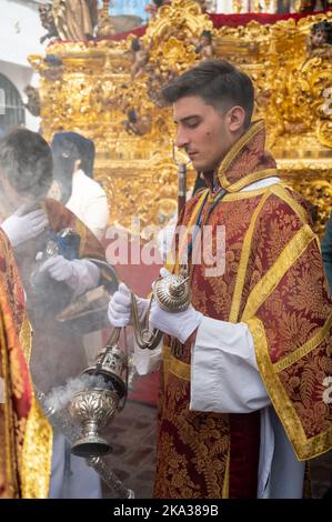 Les personnes portant des vêtements traditionnels aux couleurs vives prennent part à une parade de Pâques pendant la semaine Sainte ou le Santa de sémana à Cadix, Espagne Banque D'Images