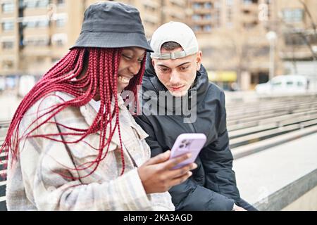 Portrait d'un couple multiethnique au téléphone, dans la rue Banque D'Images