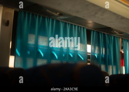 Rideaux sur la fenêtre dans le bus. Détails de l'intérieur du bus. Rideaux bleus sur la fenêtre. Banque D'Images