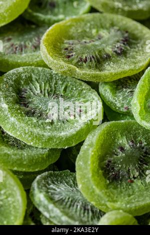 Cadre plein de pile de kiwi sec vert doux en tranches avec du sucre placé sur la surface Banque D'Images