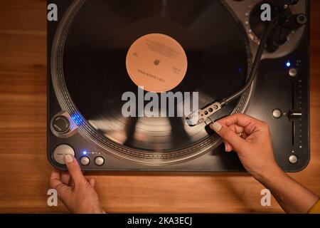 Vue de dessus de meloman anonyme mettant le stylet sur le disque vinyle placé sur le vieux plateau tournant Banque D'Images