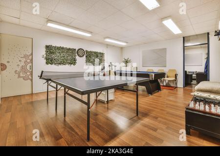 Salle de jeux confortable avec table de billard et ping-pong située dans le coin salon de l'espace de travail Banque D'Images