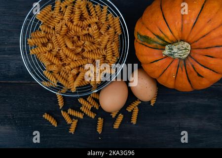 Cuisine de fond avec des nouilles de citrouille sur bois Banque D'Images