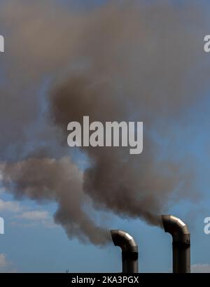 deux cheminées d'où la fumée noire sort, pollution, toxique Banque D'Images