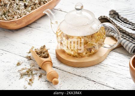 Bouilloire en verre de tisane de mousse islandaise. Pelle en bois et bol de mousse d'Islande séchée. Cetaria islandica - nom latin de la plante. Herbe alternative Banque D'Images