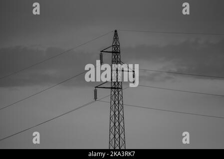 Photo en niveaux de gris d'une tour de transmission contre un ciel nuageux Banque D'Images