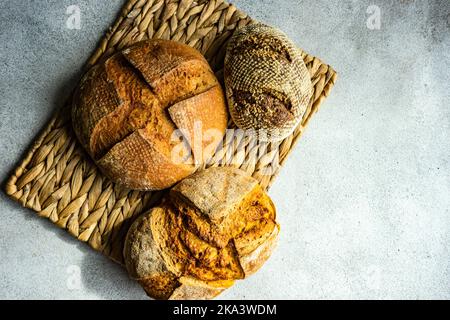 Vue en hauteur de trois pains de pain de levain fraîchement cuit sur un tapis de table Banque D'Images