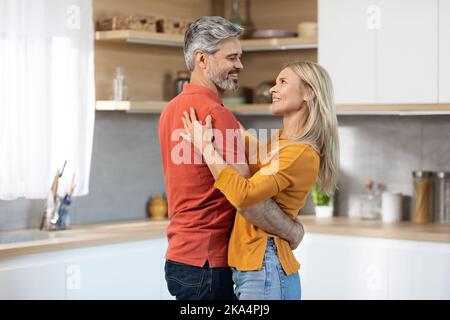 Heureusement, un couple d'âge moyen dansait dans la cuisine Banque D'Images