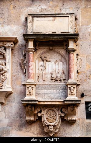 Scène de crucifixion romane de bas-relief avec colonnes doriques en marbre rose sur le front ouest de la cathédrale Saint-Étienne à Vienne, en Autriche. Banque D'Images
