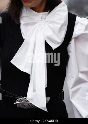 Milan, Italie - 21 septembre 2022 : femme portant un chemisier blanc à manches longues bouffantes, une ceinture noire et une veste sans manches noire Banque D'Images