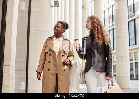 Portrait de taille vers le haut de deux jeunes femmes afro-américaines et caucasiennes regardant des fenêtres en plein air dans la ville, espace de copie Banque D'Images