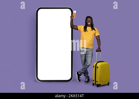 Jeune homme afro-américain voyageur debout près de matelas, mockup Banque D'Images