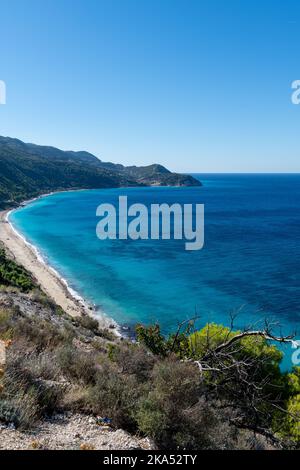 Une vue en hauteur d'une belle longue plage avec une mer claire en cristal bleu profond et un ciel bleu sans nuages. Banque D'Images