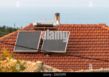 Panneaux solaires domestiques sur un toit pour le chauffage à l'eau chaude. Banque D'Images