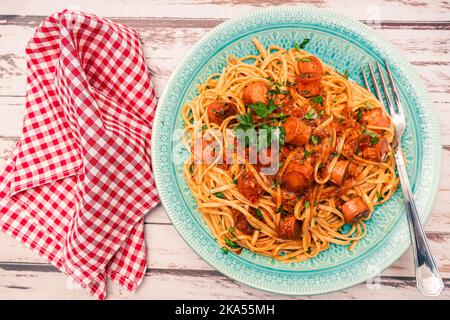 Spaghetti italiens copieux et saucisses avec sauce sur une table rustique. Vue de dessus. Banque D'Images