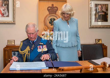 Le Prince Charles et Camilla, duchesse de Cornwall, signent le livre des visiteurs lorsqu’ils assistent à une réception en couleur de la Reine à la base de Whenuapai de la RNZAF Banque D'Images