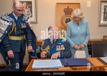 Le Prince Charles et Camilla, duchesse de Cornwall, signent le livre des visiteurs lorsqu’ils assistent à une réception en couleur de la Reine à la base de Whenuapai de la RNZAF Banque D'Images