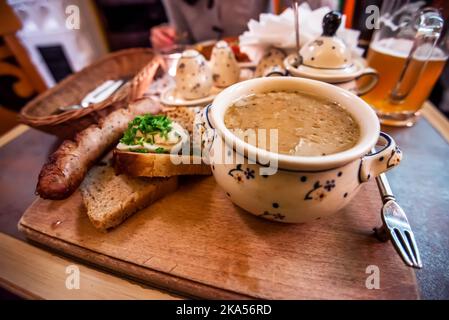 Varsovie, Pologne. Zurek, polissez la recette traditionnelle de soupe avec des œufs et des saucisses, assiette de restaurant touristique. Banque D'Images
