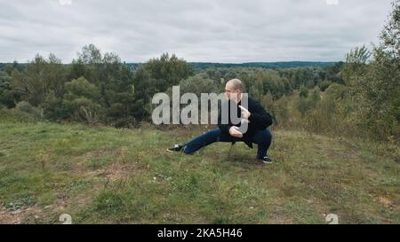 L'homme caucasien est engagé dans la gymnastique traditionnelle chinoise qigong et tai chi Banque D'Images