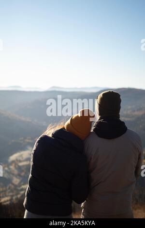 Jeune couple de derrière appréciant le paysage des montagnes d'automne dans la matinée Banque D'Images