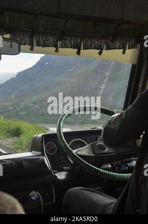 Vue arrière d'un homme non reconnu conduisant une fourgonnette de tourisme (voyageur rythmé) sur l'autoroute Manali-Leh pendant la saison estivale Banque D'Images