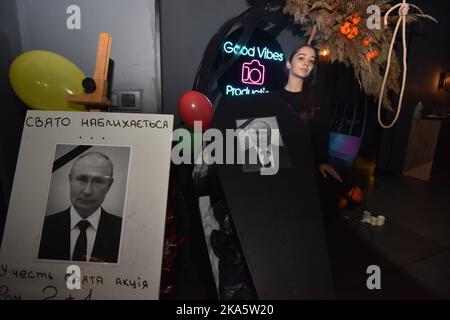 Lviv, Ukraine. 31st octobre 2022. Une fille pose avec un cercueil sur lequel un portrait du président russe Vladimir Poutine est attaché pendant la célébration d'Halloween dans l'un des bars de Lviv crédit: SOPA Images Limited/Alay Live News Banque D'Images