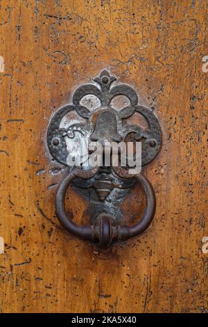 Vue rapprochée de la porte ancienne en bronze patientée sur une belle porte en bois ancienne, Montpellier, France Banque D'Images