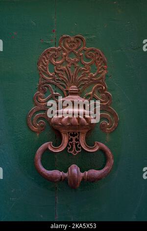 Vue rapprochée d'un magnifique knocker de porte en laiton d'époque isolé sur une ancienne porte en bois vert, Montpellier, France Banque D'Images