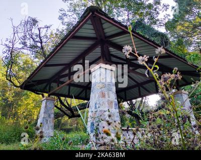 Terrasse extérieure pergola structure d'ombre en pierres et toit en métal dans un jardin. Dehradun ville Inde. Banque D'Images