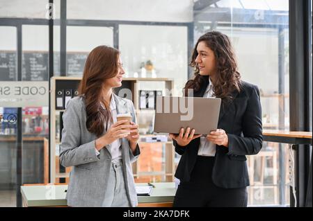 Professionnels et talentueux femmes d'affaires du millénaire caucasiennes discutant, partageant des idées et des brainstorming sur leur projet de marketing d'affaires. Banque D'Images