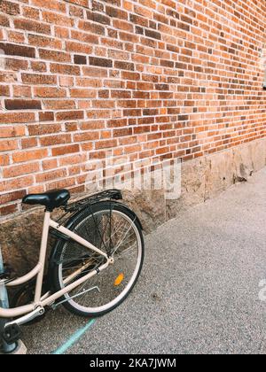 Vélo appuyé contre le mur de briques vintage dans les rues de Halmstad en Suède avec espace de copie Banque D'Images