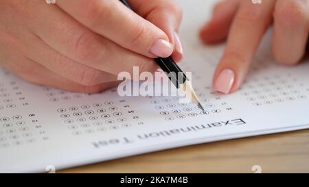 Les élèves tiennent le crayon à la main pour écrire un choix sélectionné sur les feuilles de réponses Banque D'Images