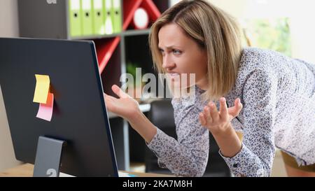 Femme contrariée regardant l'écran d'un ordinateur portable avec une expression de colère Banque D'Images