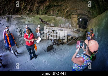 Les touristes visitant les vestiges de la deuxième guerre mondiale de la barge de transport japonais dans le tunnel de barge. Rabual, Île de la Nouvelle-Bretagne, Papouasie-Nouvelle-Guinée Banque D'Images