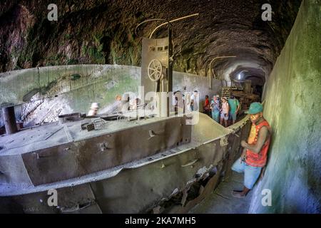 Les touristes visitant les vestiges de la deuxième guerre mondiale de la barge de transport japonais dans le tunnel de barge. Rabual, Île de la Nouvelle-Bretagne, Papouasie-Nouvelle-Guinée Banque D'Images