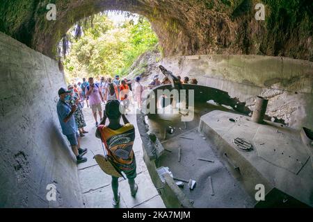 Les touristes visitant les vestiges de la deuxième guerre mondiale de la barge de transport japonais dans le tunnel de barge. Rabual, Île de la Nouvelle-Bretagne, Papouasie-Nouvelle-Guinée Banque D'Images