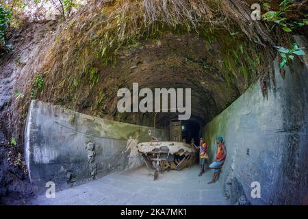 Les touristes visitant les vestiges de la deuxième guerre mondiale de la barge de transport japonais dans le tunnel de barge. Rabual, Île de la Nouvelle-Bretagne, Papouasie-Nouvelle-Guinée Banque D'Images