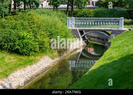 Passerelle piétonne décorative au-dessus d'un petit canal dans le parc Banque D'Images