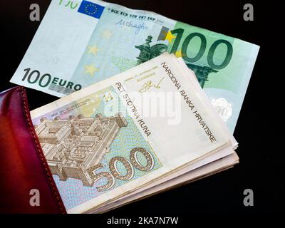 Bande de papier argent peering de portefeuille croates croates croates Kuna Kune Kunas billets et Euro européen euros fond noir Banque D'Images