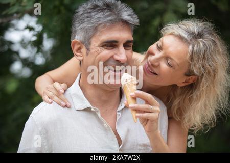 un couple d'âge moyen heureux dégusterez une crème glacée Banque D'Images