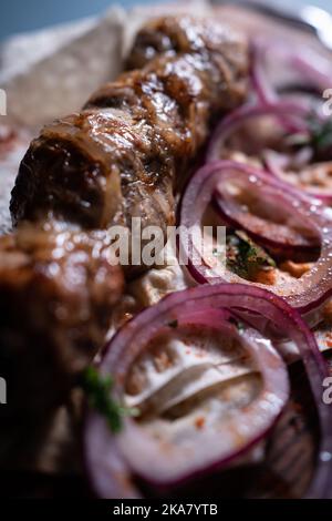 viande de porc ou de boeuf juteuse de kebab géorgien avec oignon et crème sure sur panneau de bois Banque D'Images